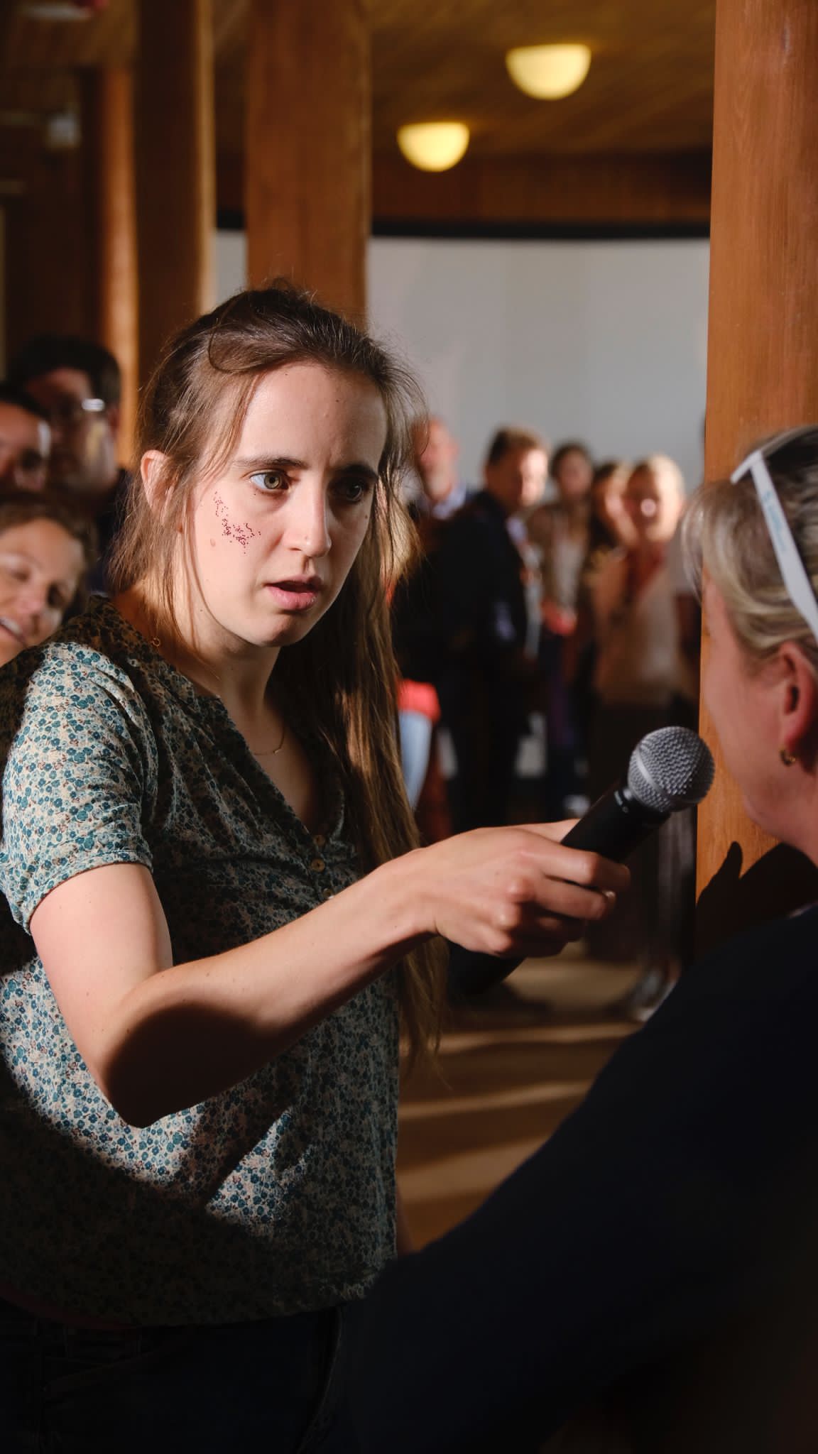 Vrouw met microfoon stelt vragen in het publiek