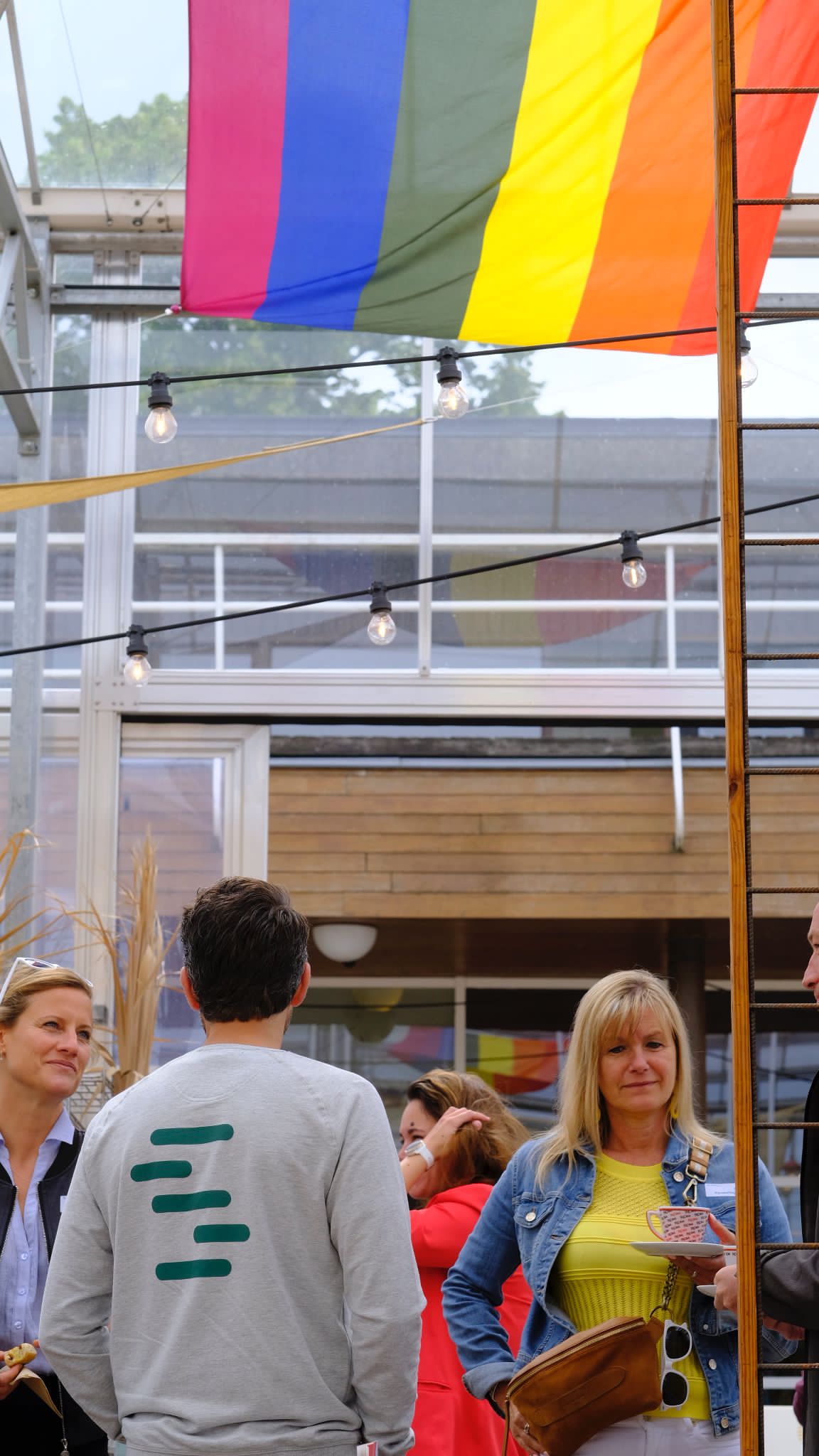 Man en vrouw staan onder regenboogvlag