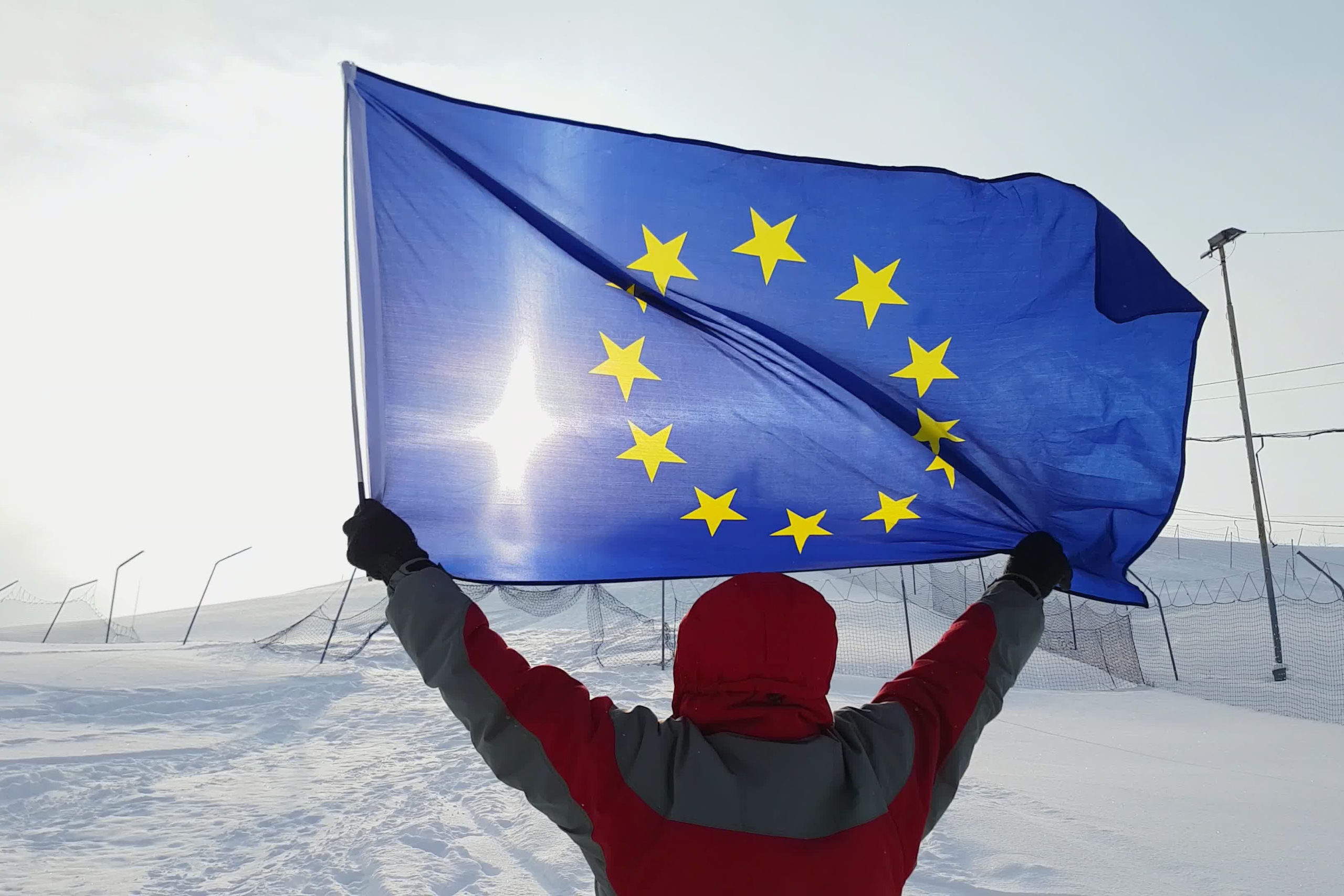 skiër houdt Europese vlag de lucht in