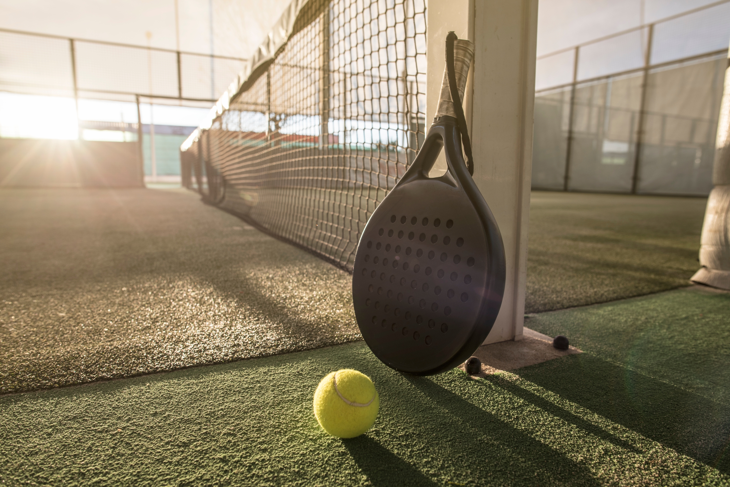 padelveld met racket op de voorgrond