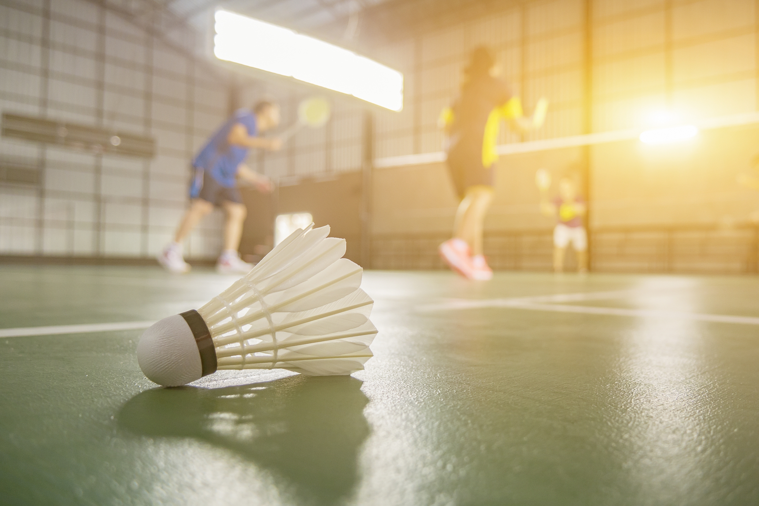 sportzaal met badminton shuttle op de vloer