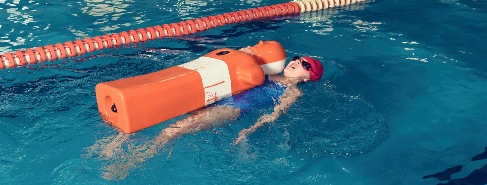 Meisje zwemt met pop in zwembad