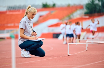 een atletiektrainer neemt notities tijdens training