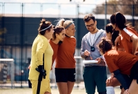 vrouwenteam staat op het veld rondom de coach