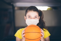 meisje met basketbal en mondmasker